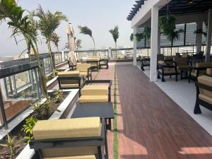 a restaurant with chairs and tables on a balcony at Hôtel NGOR ALMADIES 4 étoiles in Dakar