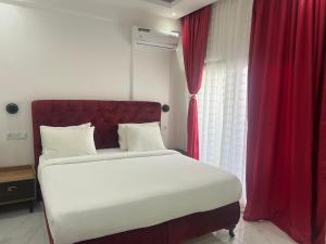 a bedroom with a large bed with a red curtain at Hôtel NGOR ALMADIES 4 étoiles in Dakar