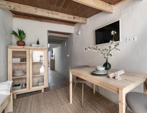 a dining room with a wooden table and a tv at Calderona Tiny house in Segorbe