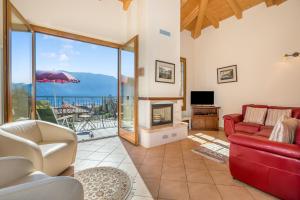 a living room with a red couch and a fireplace at Tremezzo Ulivi Apt.7 in Tremezzo