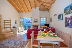 a living room with a table and a red couch at Tremezzo Ulivi Apt.7 in Tremezzo