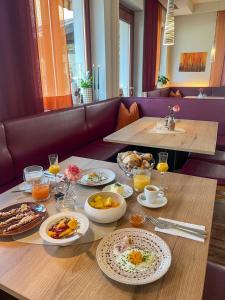 ein Tisch mit Tellern voller Essen darauf in der Unterkunft Hotel Sommerer - Hike & Bike in Saalbach, Joker Card inkl in Saalbach-Hinterglemm