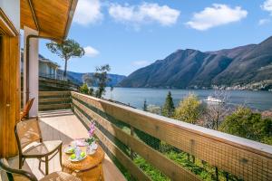 a balcony with a table and chairs and a view of the water at Villa Marilyn in Nesso
