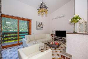a living room with a white couch and a tv at Villa Marilyn in Nesso