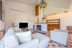 a living room with a white couch and a fireplace at Villa Marilyn in Nesso +33 photos