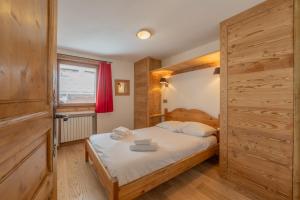 a bedroom with a bed and a large wooden door at Apt Clusettes 1-min walk to ski + parking & WiFi - Happy Rentals in Chamonix