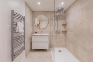 a bathroom with a sink and a shower with a mirror at Apt Clusettes 1-min walk to ski + parking & WiFi - Happy Rentals in Chamonix +20 photos