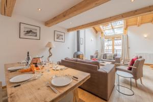a living room with a table and a couch at Apt Clusettes 1-min walk to ski + parking & WiFi - Happy Rentals in Chamonix