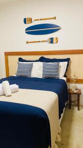 a bedroom with two beds with blue and white pillows at Casa Rústica com Spa in Arraial d'Ajuda +19 photos