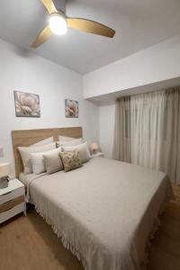 a bedroom with a large bed with a ceiling fan at Alojamiento Baeza - Leones 9 A in Baeza