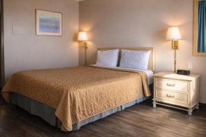 a hotel room with a bed and two night stands at Tree Inn & Suites Albuquerque in Albuquerque