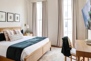 a bedroom with a bed and a desk and windows at Expansive 7 Bedroom Home Heated Pool & Spa in New Orleans