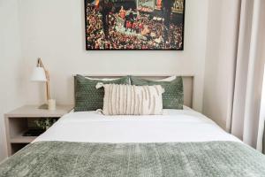 a bedroom with a bed with a blanket and a picture at Expansive 7 Bedroom Home Heated Pool & Spa in New Orleans