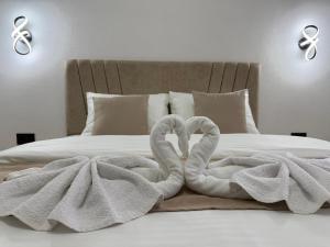 a bed with two towels shaped like swans on it at Apartman Đole&Ljuba -Radanovići , Kotor in Ðuranovići