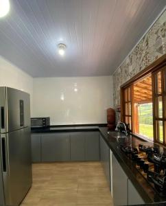 a kitchen with a stainless steel refrigerator and a counter at Sítio Anna in São Thomé das Letras