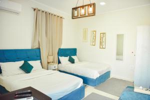 two beds in a room with blue and white at LALA LAND Fayoum in Tunis