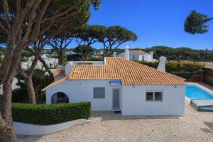 a white house with a pool in front of it at Villa 7 - Vale do Lobo in Almancil