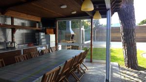 an outdoor kitchen with a long table and chairs at Villa 7 - Vale do Lobo in Almancil