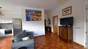 a living room with a couch and a flat screen tv at Villa 7 - Vale do Lobo in Almancil