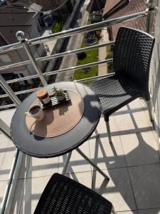 a table with a hat and two chairs on a balcony at M Premium Apartments in Paraćin