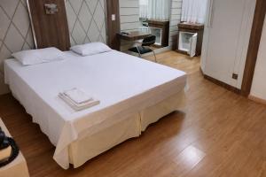 a bedroom with a large white bed and a chair at Paraná Comfort Hotel in Cianorte +41 photos