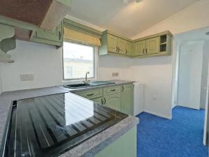 a kitchen with green cabinets and a counter top at Minster - Uk51005 in Eastchurch