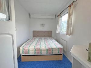 a bedroom with a bed in a white room at Minster - Uk51005 in Eastchurch