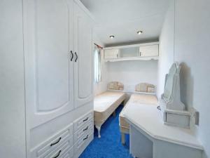 a small room with two beds and a desk at Minster - Uk51005 in Eastchurch +5 photos