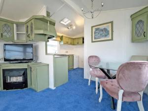 a room with a table and chairs and a television at Minster - Uk51005 in Eastchurch