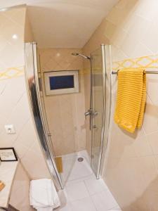 a shower with a glass door in a bathroom at Casinha Amarela in Cabeção +66 photos