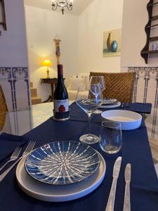 a table with a bottle of wine and plates and glasses at Casinha Amarela in Cabeção