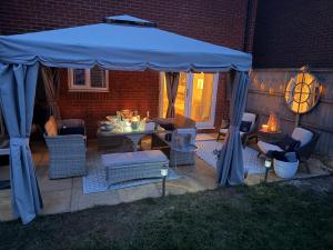 a blue tent on a patio with chairs and a table at Southkey House in Repton