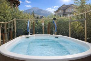 a hot tub in a backyard with a fence at Mountain Paradise at Falcon Crest Lodge in Canmore