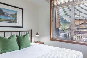 a bedroom with a bed and a large window at Mountain Paradise at Falcon Crest Lodge in Canmore