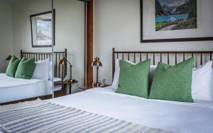 two beds with green pillows in a bedroom at Mountain Paradise at Falcon Crest Lodge in Canmore +93 photos