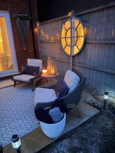 a patio with a chair and a table and a clock at Southkey House in Repton