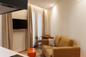 a living room with a couch and a television at Blume Cruz Suites in Madrid