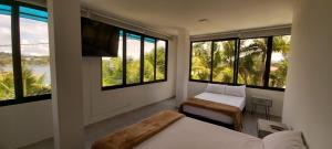 a bedroom with two beds and a tv and windows at Hotel Mirador Cielo Azul in Horizonte +75 photos