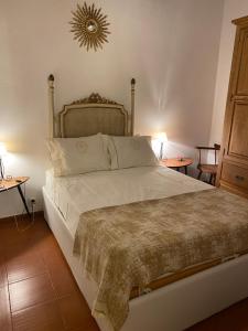 a bedroom with a large bed with two tables at Casinha Amarela in Cabeção
