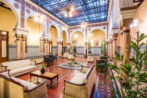 巴蘭基亞的住宿－Hotel Majestic，大楼内带桌椅的大堂
