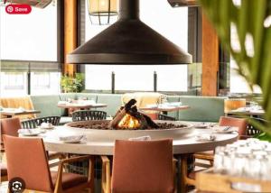 a restaurant with a large fire pit in the middle of a table at Inspired Elegance at Tamarack Lodge in Canmore