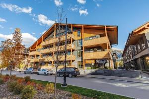 a building with cars parked in front of it on a street at Inspired Elegance at Tamarack Lodge in Canmore