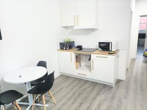 a kitchen with a table and chairs and a microwave at Waldstreet in Rüsselsheim