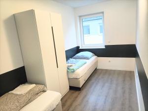 a small room with two beds and a window at Waldstreet in Rüsselsheim