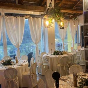 a room with white tables and chairs and a large window at B&b Oca Carolina in Buttigliera Alta +182 photos