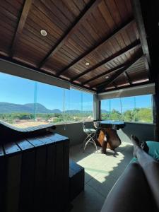 a room with a table and a desk and windows at Espaço Verano- Master 1 in Niterói