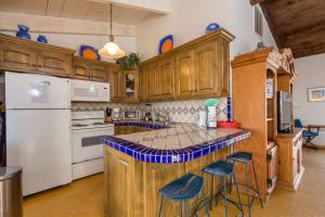a kitchen with wooden cabinets and a counter with stools at Spacious Oceanview Home Casa de Los Amigos in Puerto Peñasco