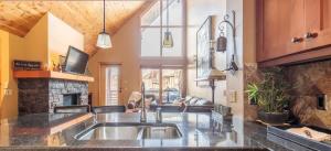 a kitchen with a sink and a living room at Utopia at Rundle Cliffs Lodge in Canmore
