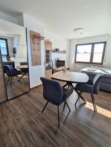a room with a table and chairs and a bed at Haus Ausreißer 2 - Hafennest in Bensersiel