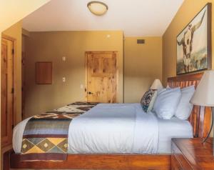 a bedroom with a white bed in a room at Utopia at Rundle Cliffs Lodge in Canmore